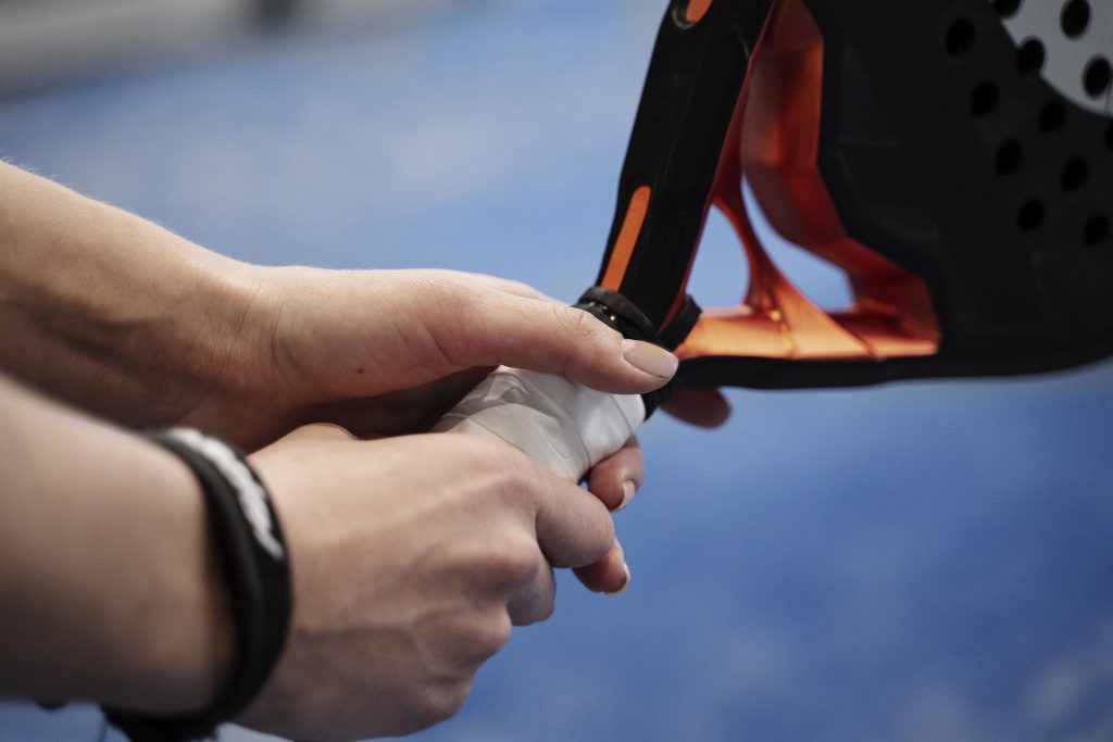 side view hands holding tennis palette