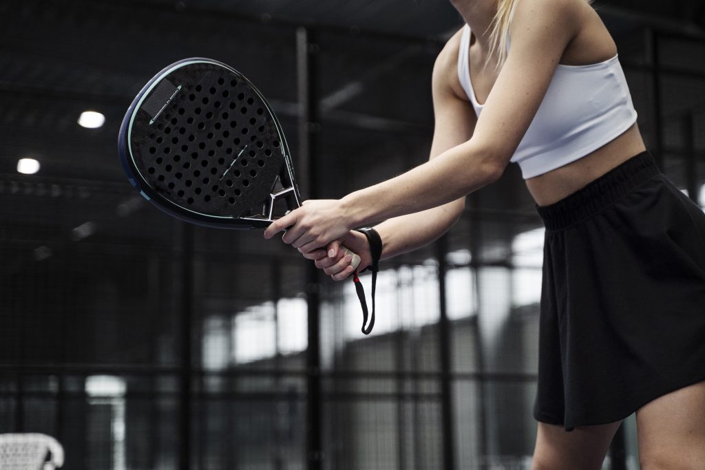 side view woman playing paddle tennis