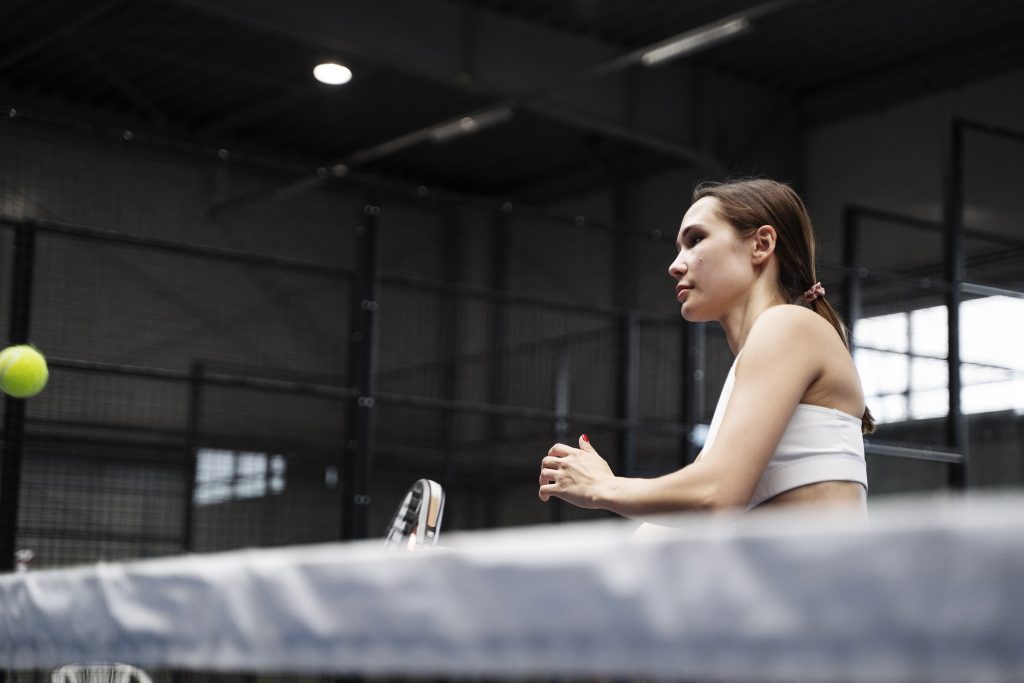 side view young woman playing paddle tennis